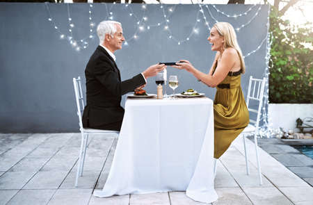 She loves it when I surprise her with unexpected gifts. Shot of a mature couple out on a romantic date.の写真素材