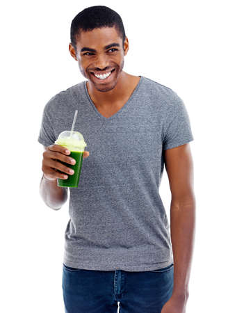 Green smoothie goodness. Studio shot of a handsome young man enjoying a fruit smoothie.の写真素材