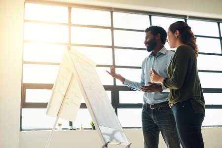 Mixing bright ideas with a meticulous attention to detail. Shot of two businesspeople brainstorming...