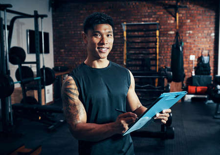 Would you like to be a member. Shot of a personal trainer holding a clipboard.