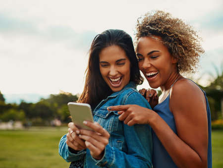 This is that app I was talking about. Cropped shot of two attractive young girlfriends using a...