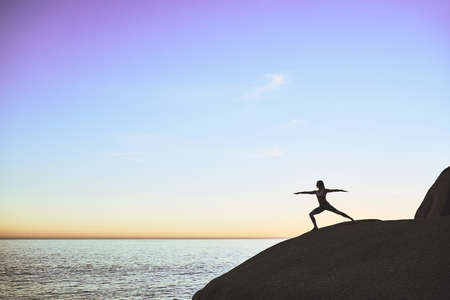 Yoga benefits the mind and body. Shot of an athletic young woman practicing yoga on the beach.の写真素材
