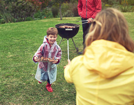 Barbecues are the best. Shot of a family enjoying a barbecue outside.の写真素材