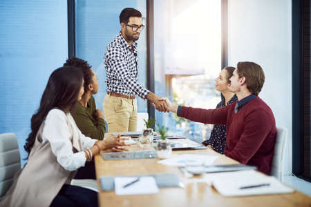 Thank you for your commitment to excellence. Shot of a businessman shaking his colleagues hand in a...