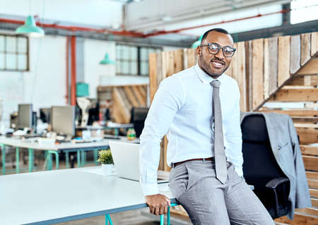 His success story is one all should hear. Portrait of a young businessman standing in an office.の写真素材