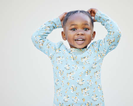 Someone just broke the cute meter. Shot of an adorable little girl standing against a white...