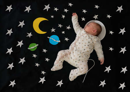 Dream big little one. Conceptual shot of a baby girl as an astronaut against a space background.の写真素材
