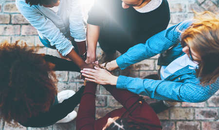 Theyll achieve their dreams together. High angle shot of an unrecognizable group of college friends standing outside with their hands in a huddle.の写真素材