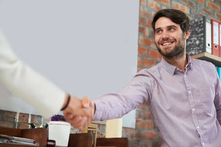 Welcome to the team. A young business man shaking hands with someone.の写真素材