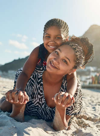 Its our girls only day. Portrait of a mother and her little daughter enjoying some quality time together at the beach.の写真素材