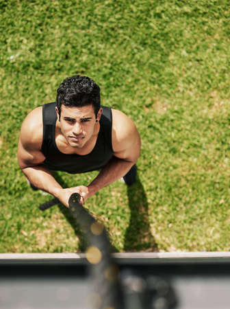 I can and I will. High angle shot of a young sportsman holding on to a rope during his workout.