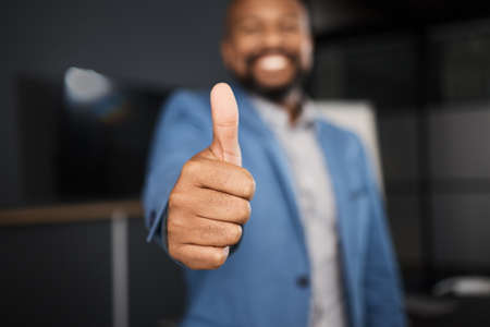 Thank you for al your efforts. Closeup shot of an unrecognisable businessman showing thumbs up in an office.の写真素材