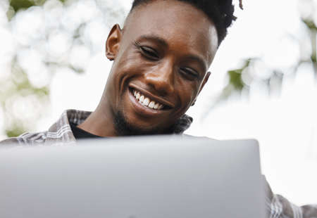 Dedicated and determined. Shot of a young man using a laptop on campus.の写真素材