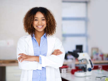 Ill find the cure. Portrait of an attractive young scientist standing with her arms folded in the lab.の写真素材