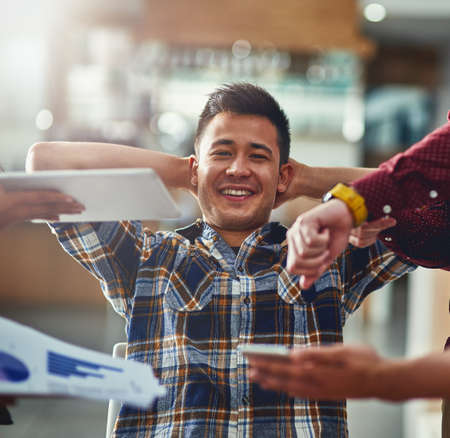 Work is easy-peasy. Portrait of a young designer looking calm in a demanding office environment.の写真素材