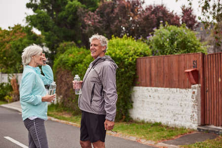 We got our exercise in for the day. Cropped shot of a cheerful senior couple drinking water after...