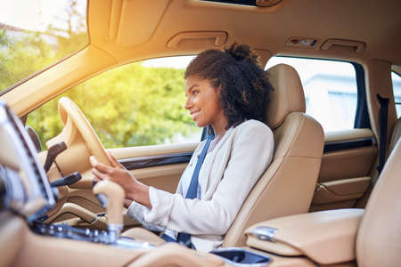 She enjoys her morning commute. Cropped shot of an attractive young businesswoman driving to work on...