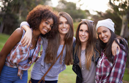 Best friends hanging out in the park. Cropped shot of a group of young women enjoying the outdoors together.の写真素材