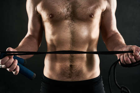 No workout is complete with a little skipping. Studio shot of a mans torso while holding a skilpping...