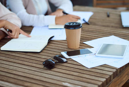 Meeting in progress. Cropped shot of a group of unrecognizable businesspeople sitting in the boardroom during a meeting.の写真素材