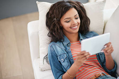 Enjoying the internet and all its freedom. High angle shot of a young woman using her digital tablet...