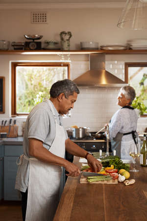 Mariage is 5050. Shot of a happy mature couple cooking a meal together at home.の写真素材