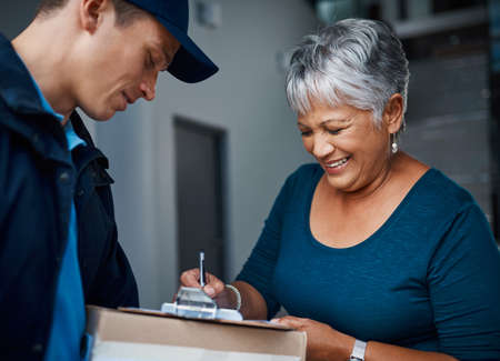 Another happy customer. Cropped shot of a handsome young man delivering a package to a customer.