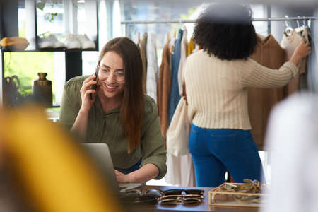 Your order is packed and on its merry way. Shot of a woman talking on her cellphone while working in...