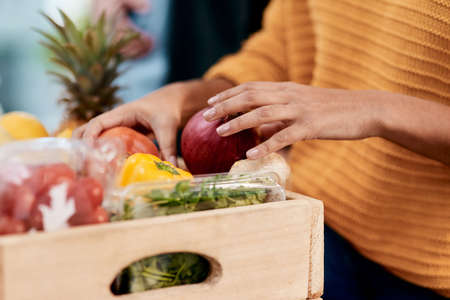 Good health makes good sense. Cropped shot of a woman unpacking her groceries in the kitchen at home.の写真素材