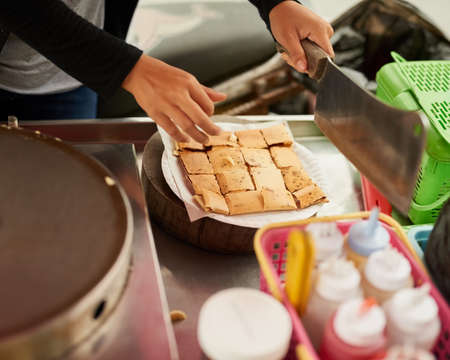 Fresh and delicious. Shot of an unidentifiable food vendor in Thailand preparing a tasty snack.の写真素材