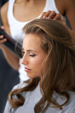 Taking a day to treat herself - Beauty treatment. A beautiful young woman spending the day getting her hair and makeup done.の写真素材