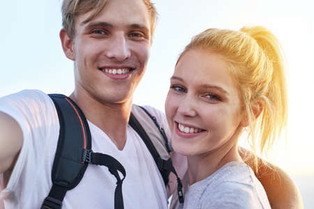 We made it to the top, and heres the proof. Cropped portrait of a young couple on a hike.の写真素材