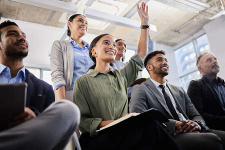 Waiting with baited breath. Shot of a group of business people asking questions during a conference.の写真素材