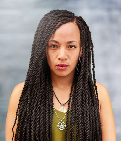 Long an beautiful braids. Portrait of an attractive young woman with beautiful braids posing...
