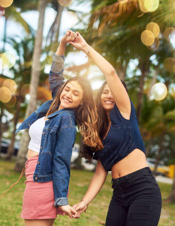 I have so much fun with her. Cropped shot of two female best friends being playful in a public park.