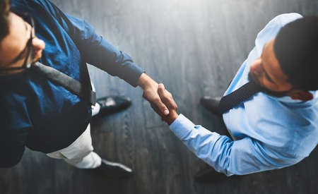 Its a done deal. Shot of two businessmen shaking hands in an office.の写真素材