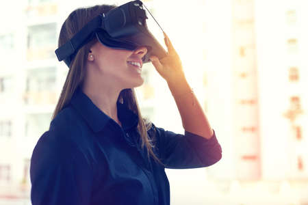 Its every visionarys dream tool. Shot of a young businesswoman wearing a VR headset in an office.