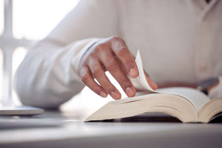Without labor, nothing prospers. Shot of an unrecognizable male reading a book at home.