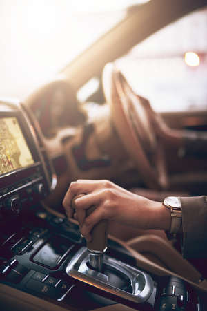 Drive towards your ambitions. Shot of an unidentifiable businesswoman changing the gears while...