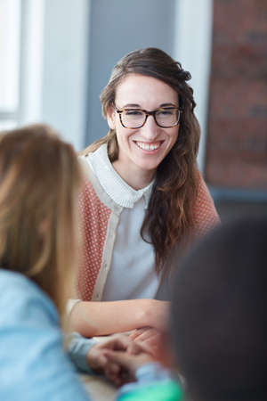 Happy on campus. Portrait of a young university student sitting in her classroom during a group project.の写真素材