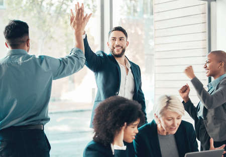I knew you had it in you. Shot of a diverse group of businesspeople celebrating a success during a meeting in the office.の写真素材
