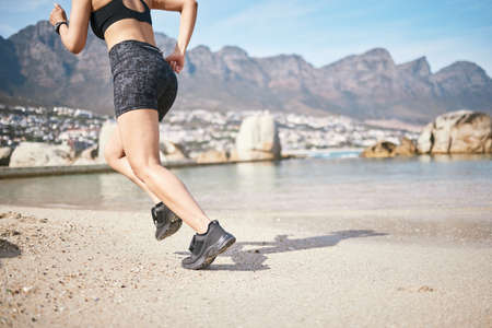Shes setting a strong pace. Low angle shot of an unrecognizable athletic young woman out for a run...