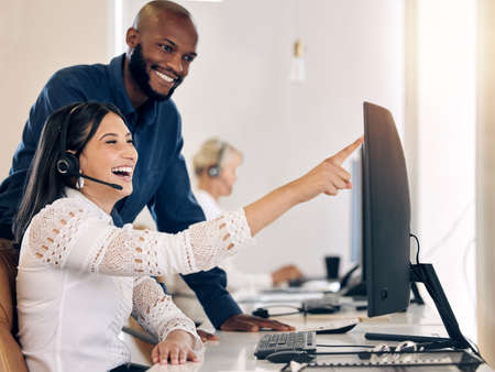 Identifying and addressing customer needs. Shot of two call centre agents working together on a...