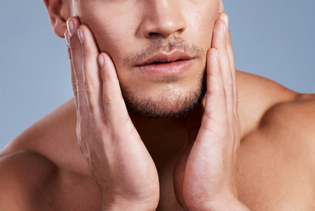 You skin needs that extra TLC. Cropped shot of a man posing against a grey background.の写真素材