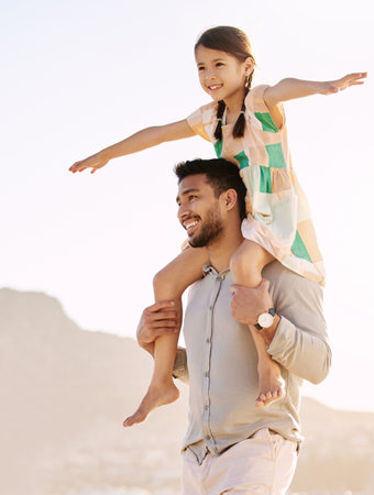 Riding high on daddys shoulders. Cropped shot of a handsome young man carrying his daughter on his shoulders at the beach.の写真素材