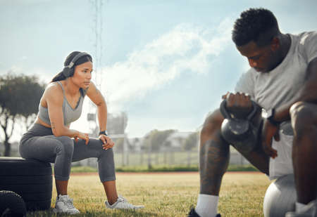 Staying healthy, together. Full length shot of a young athletic couple exercising together outdoors.の写真素材