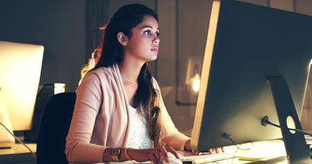 Completing the task with utmost concentration. Cropped shot of a beautiful young woman working at...