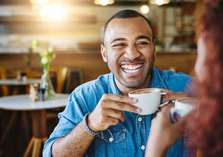 He loves spending time with her. Cropped shot of a handsome young man spending time with his girlfriend in a coffee shop.の写真素材