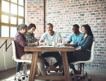 Team. Together everyone achieves more. Shot of a team of entrepreneurs collaborating in a modern office.の写真素材