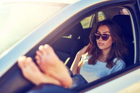 The freedom of the roadtrip. Shot of a young woman sitting in her car.の写真素材